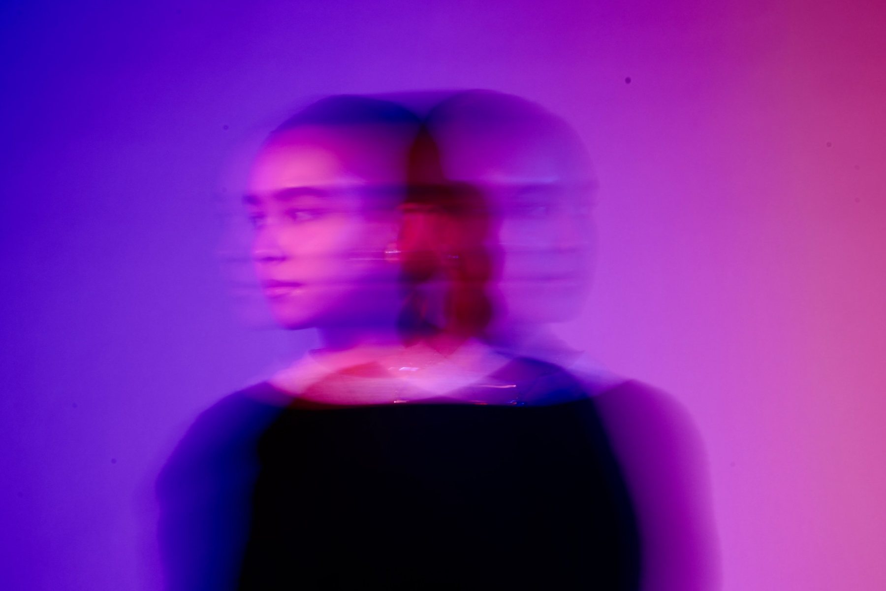 Double-exposure motion-blur portrait in violet and magenta light
