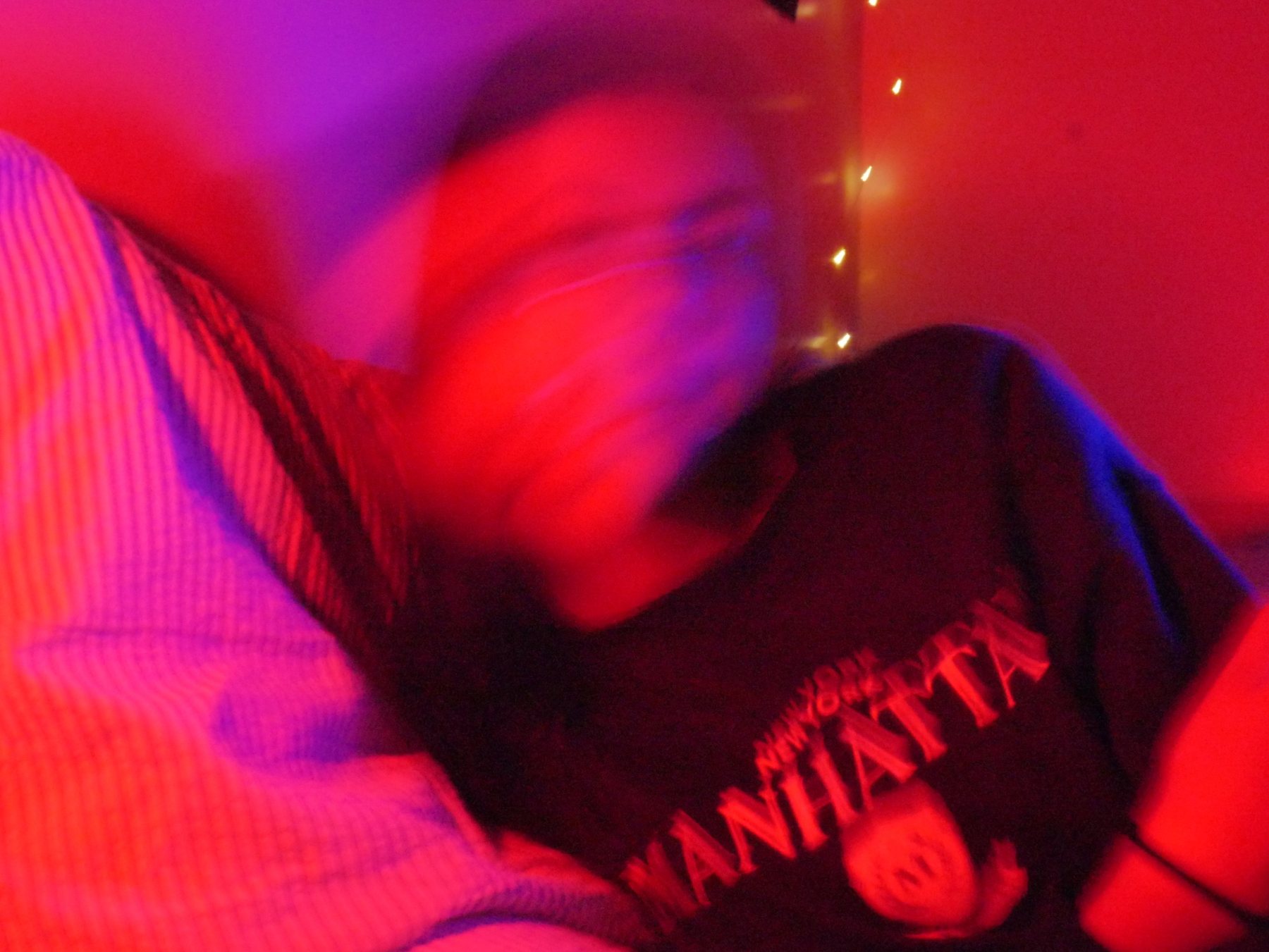 Smiling face smeared by motion in deep red light