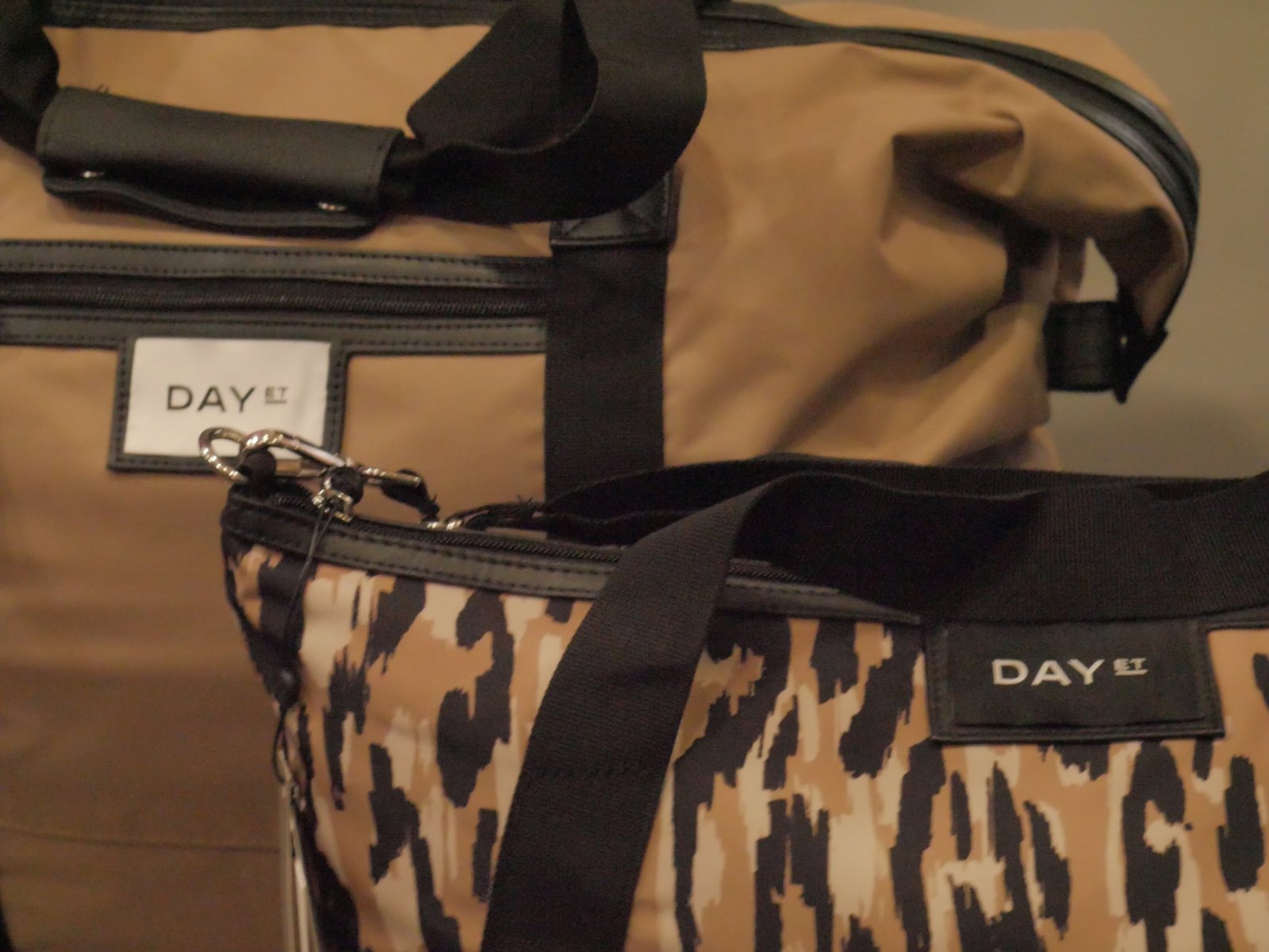 Close-up of a camel holdall and a leopard-print bag