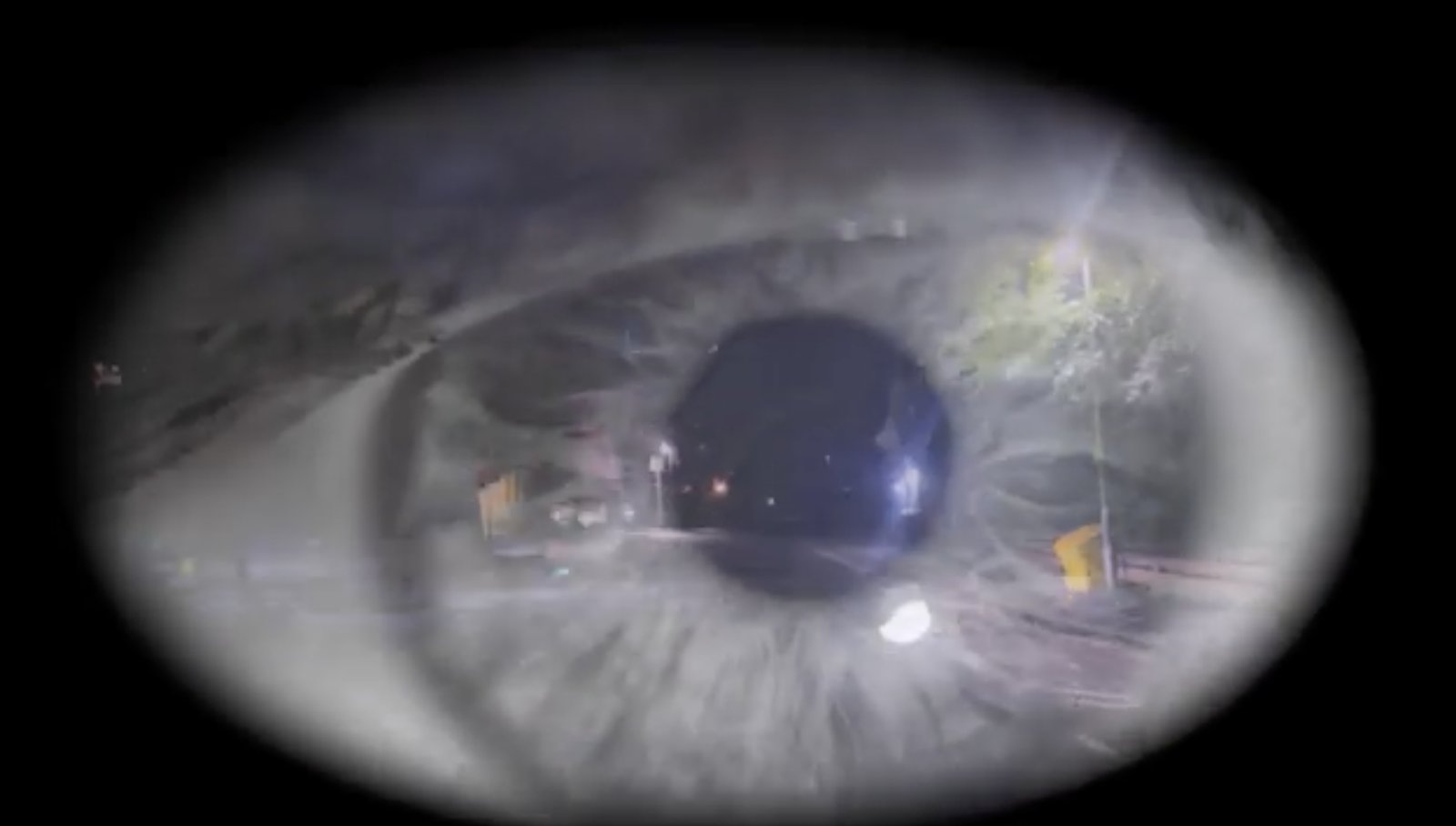 Still from Experimental Surreal Film: a close-up eye with a night street scene reflected in the iris
