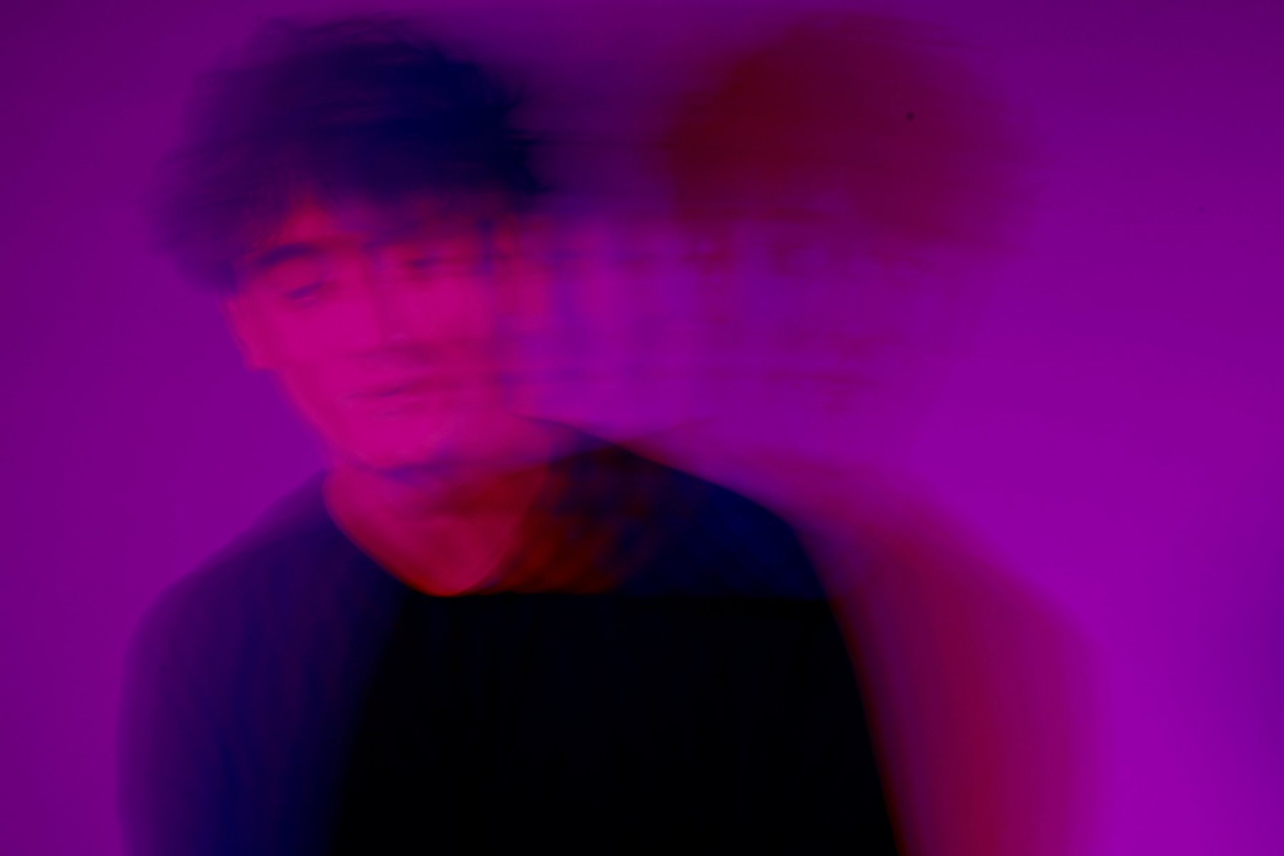Blurred double portrait glowing magenta on a purple background